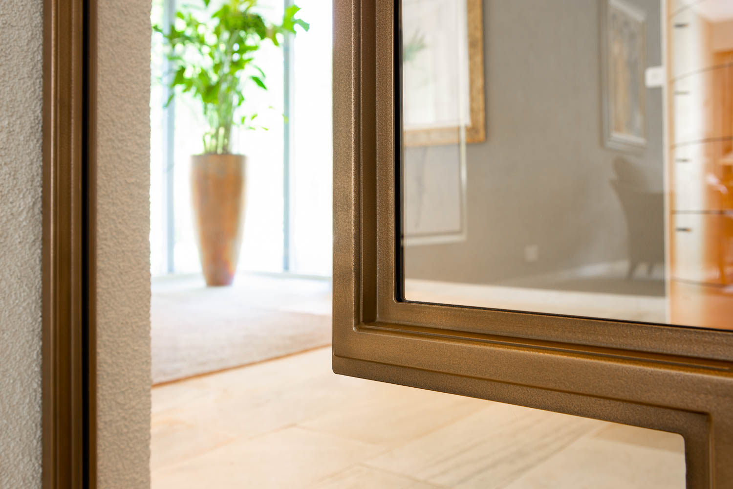 Detail van een bronzen stalen deur met glas, verfijnde afwerking en moderne uitstraling.